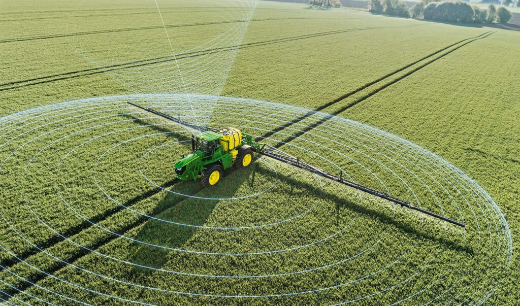 Обприскувач працює на зеленому полі, показано рівномірне розпилення.